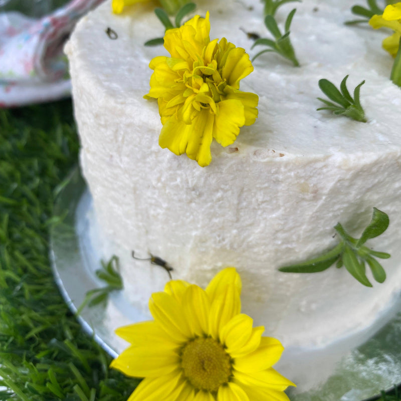A chicken frosted meat cake for pets, covered in edible flowers