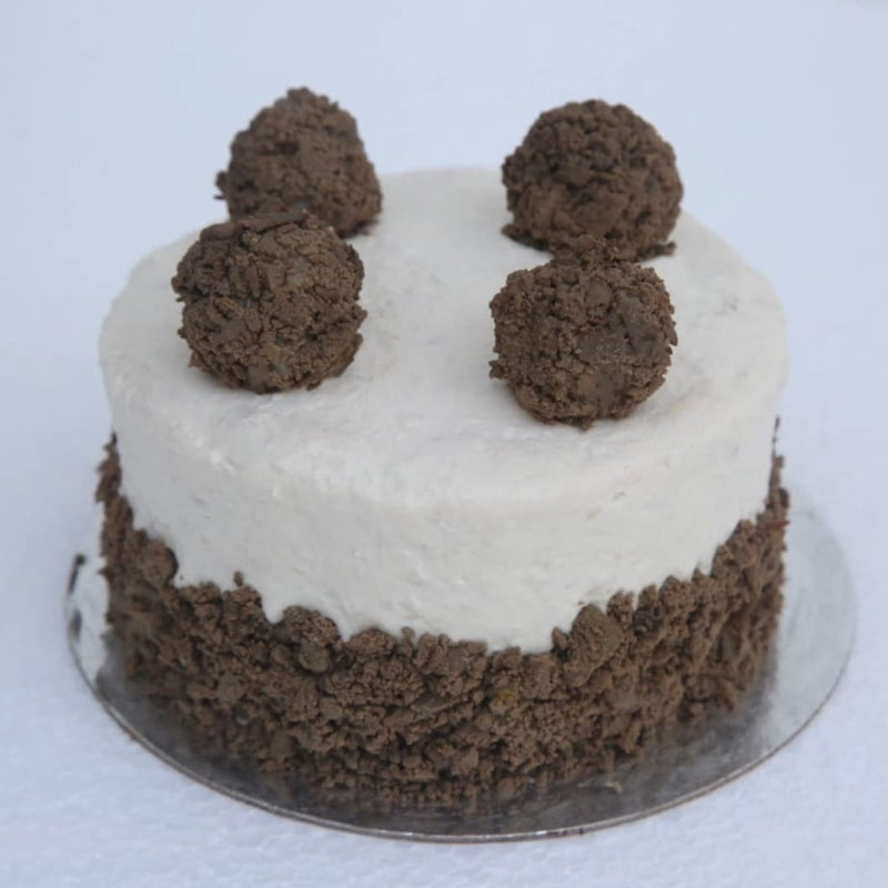 A meat cake for dogs, covered in chicken frosting and crumbled liver to represent an Oreo