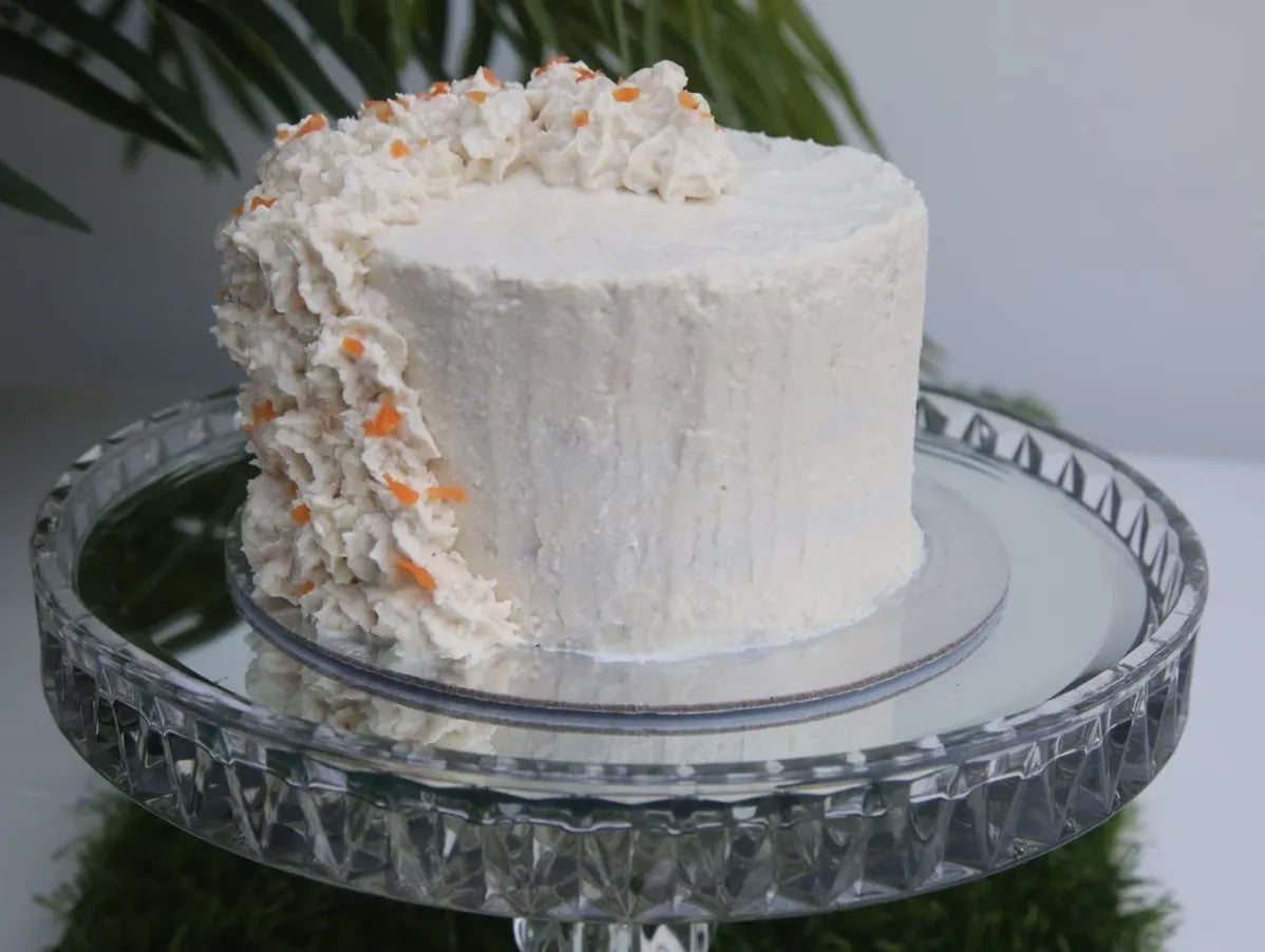 A meat cake for pets covered in chicken frosting and chicken parfait swirls, served on a glass platter