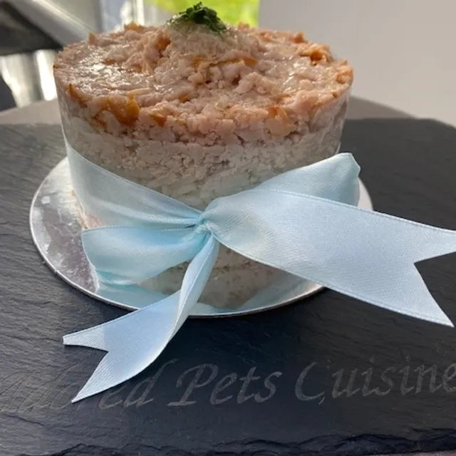 A meat cake for pets presented with a blue ribbon on a slate board